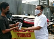 Salah satu anggota E Sport Gresik membagi masker kepada warga yang membutuhkan, Sabtu (17/7/2021)