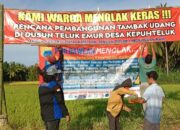 Mahasiswa PMII Bawean memasang spanduk penolakan rencana pembangunan tambak udang di Dusun Telukkemur Desa Kepuhteluk Kecamatan Tambak Pulau Bawean, Senin (23/8/2021).