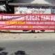 Pedagang di Telaga Ngipik Gresik membeber spanduk protes rencana pembongkaran stand, Senin (16/8/2021).