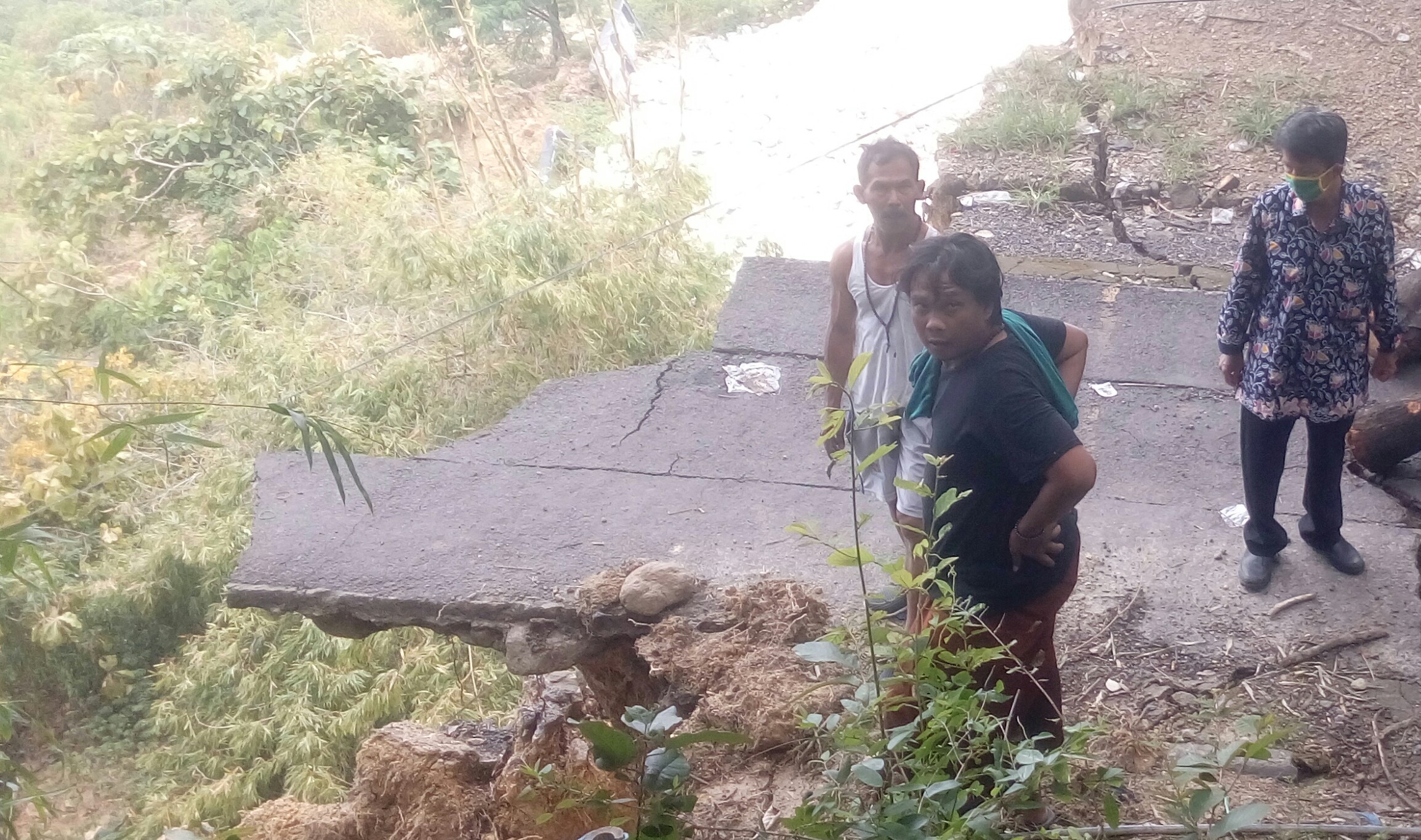 Warga saat melihat jalan yang terputus akibat longsor tebing sisi timur bukit Putri Cempo Gresik bulan Februari lalu.