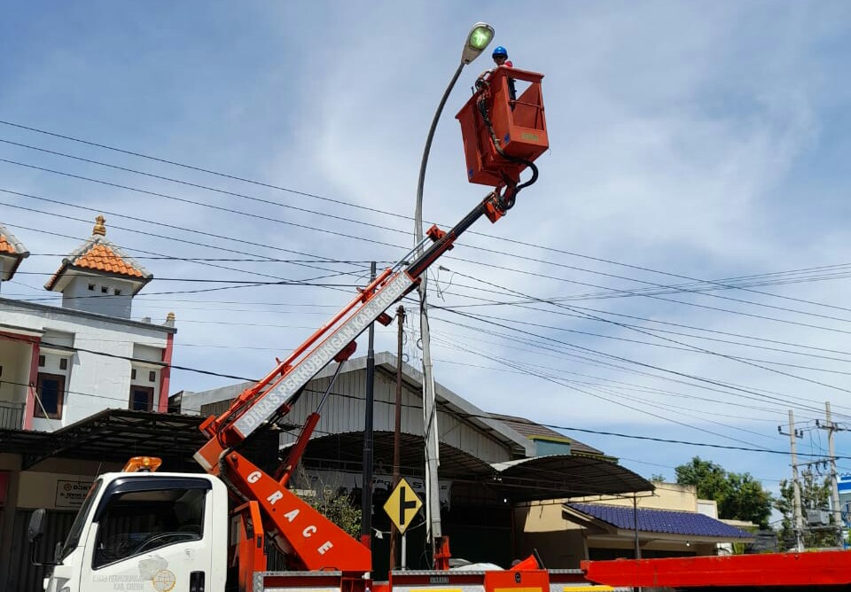 Petugas Dishub Gresik sedang melakukan perawatan dan pemeliharan PJU listrik di poros jalan Ujungpangkah, Rabu (15/9/2021) lalu. /Foto: Dishub Gresik