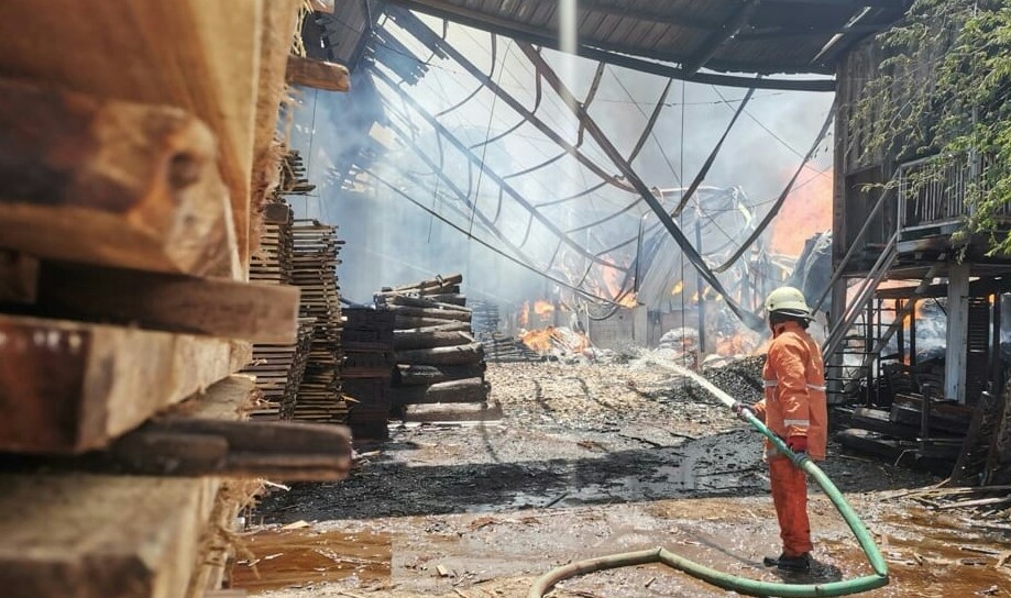 Petugas sedang melakukan pembasahan di PT Karya Mandiri di Jalan Mayjend Sungkono Desa Sekarkurung Kecamatan Kebomas Kabupaten Gresik yang terbakar, Rabu (13/10/2021)./Foto: Bram