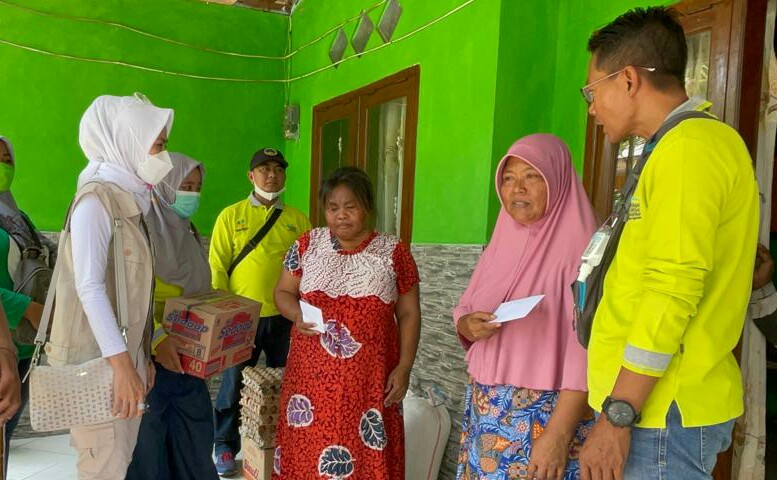 Sumi (30) dan Karsan (40) terima bantuan sembako tim pendamping Program Keluarga Harapan (PKH) Gresik dan tim PKH Wringinanom, Jumat (15/10/3031)./ Foto: Bram