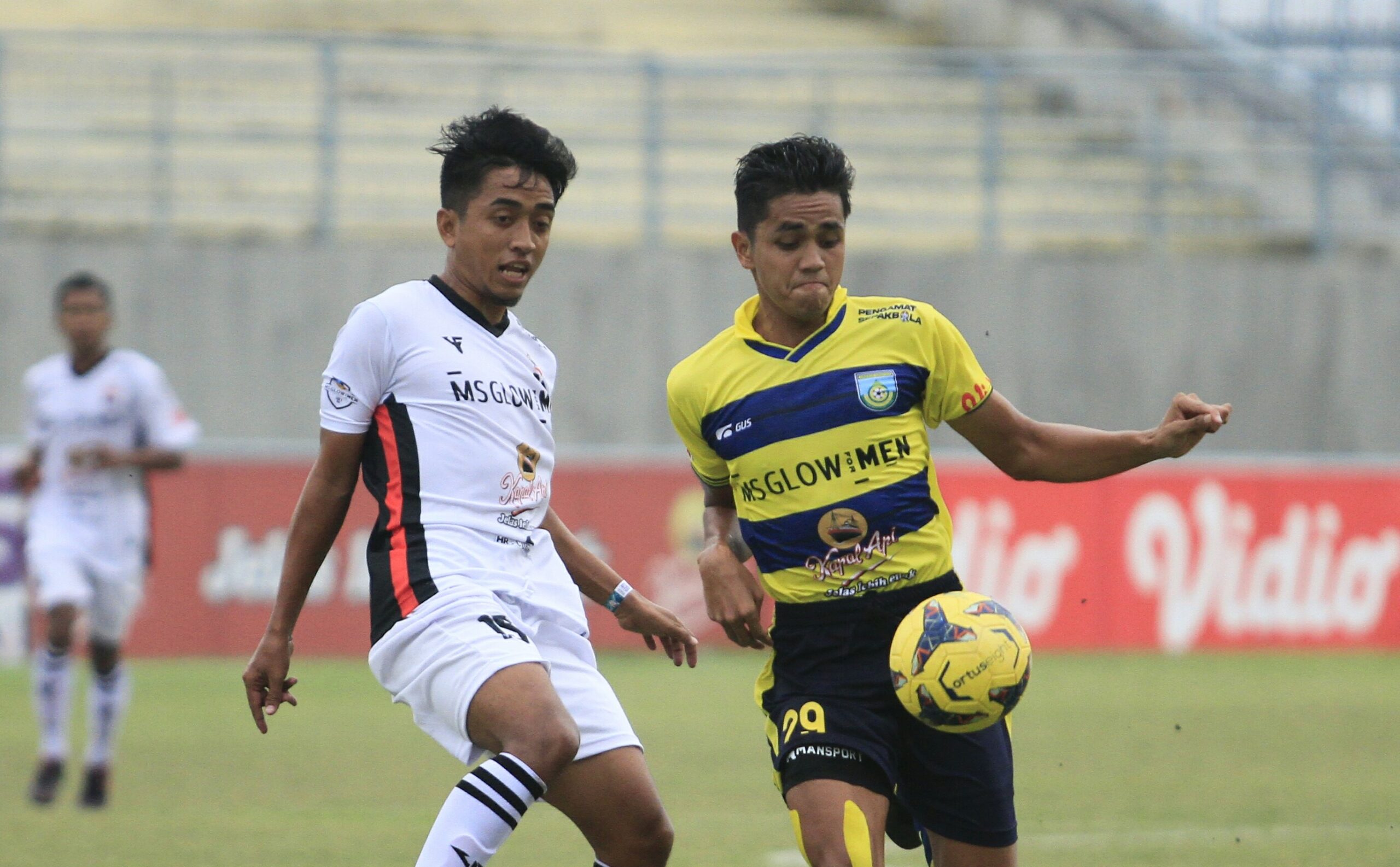 Pemain Gresik United (kuning) berusaha lepas dari kawalan pemain FC Maestro pada laga liga 3 grup C, Sabtu (13/11/2021) di Gelora Joko Samudero./ Foto: Bram