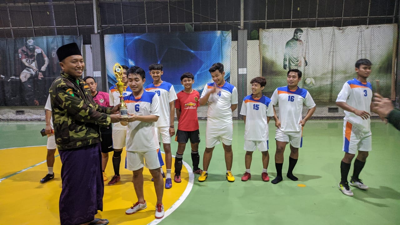 Ketua Gerakan Pemuda Ansor Kecamatan Balongpanggang, Samsul Arif memberi tropy kepada tim juara futsal. /Foto: Bram