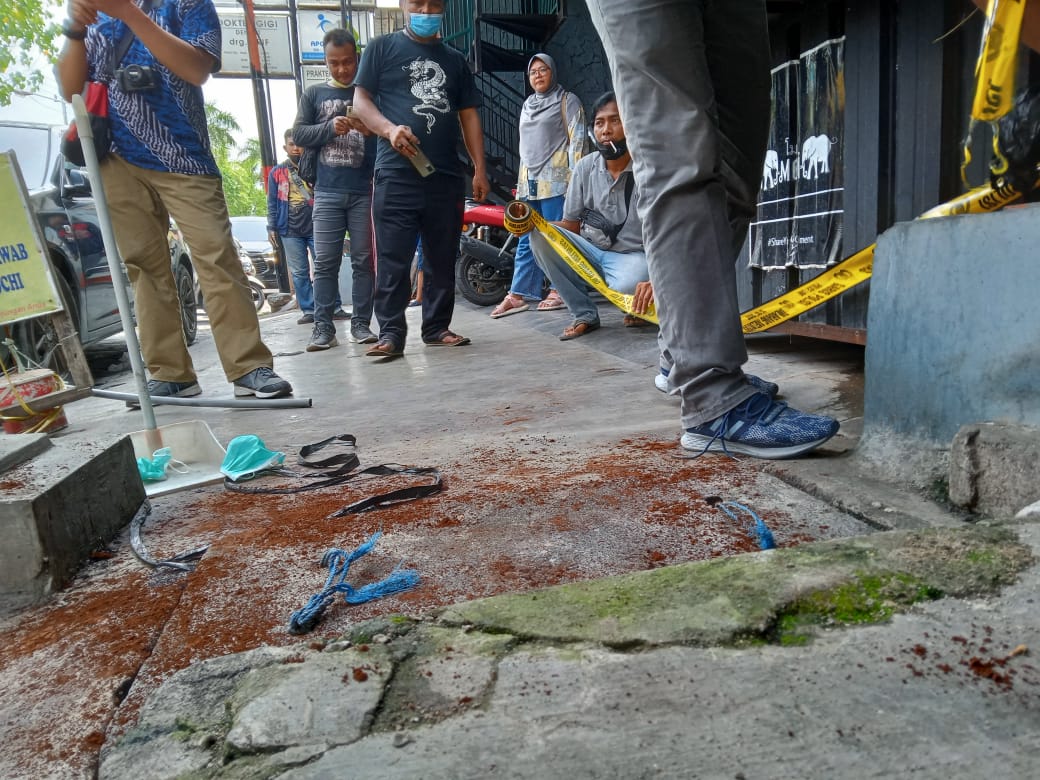 Petugas sedang memasang garis Polisi di sekitar slokan tempat ditemukannya korban depan rumah makan Jepang di Jalan Kalimantan, GKB, Rabu (10/11/2021)./ Foto: Bram