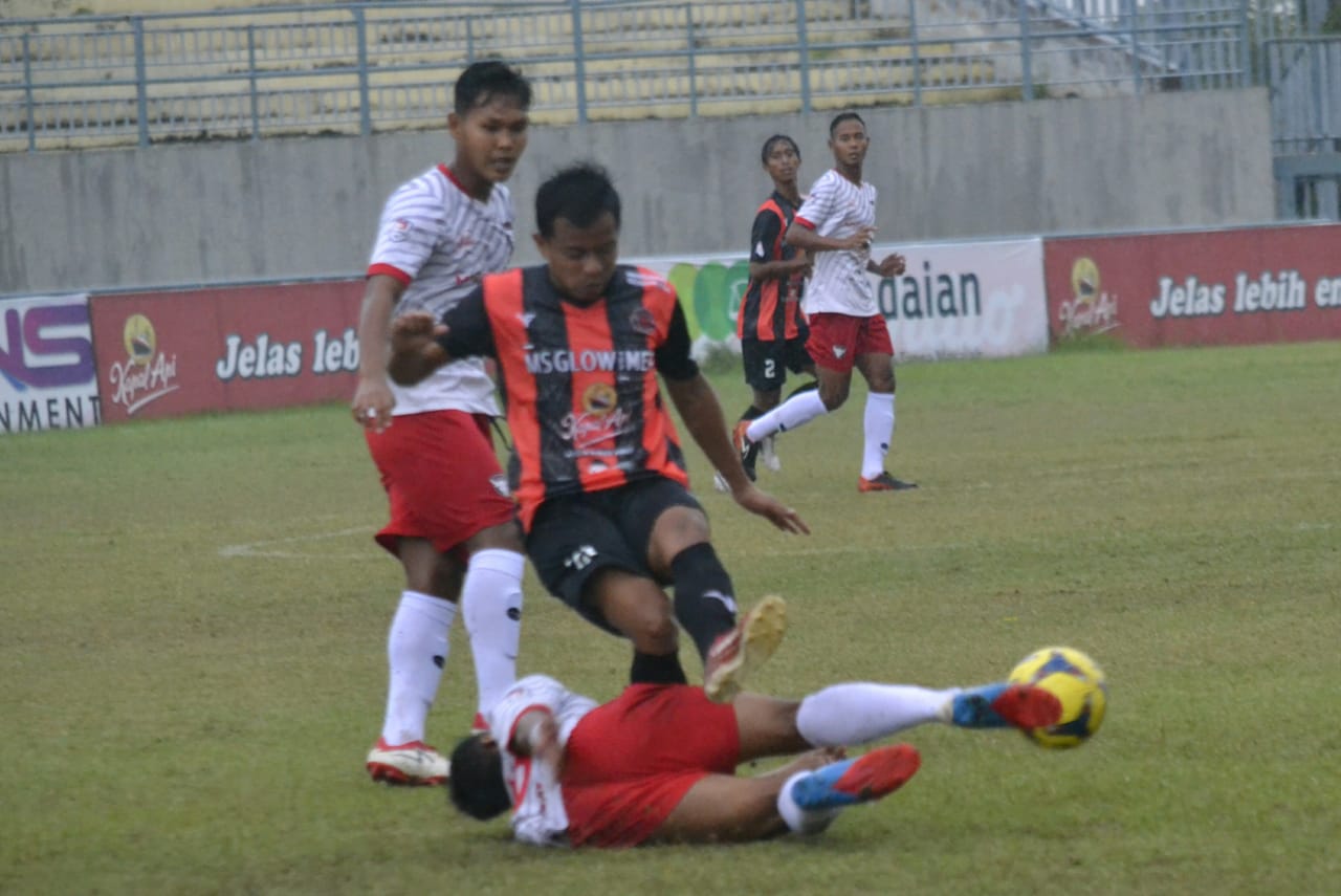 Pemain PDS (hitam merah) berusaha melewati tackling pemain Madura FC, Senin (6/12/2021) di stadion Gelora Joko Samudero pada Liga 3 regional Jawa Timur babak 16 besar. / Foto: Bram
