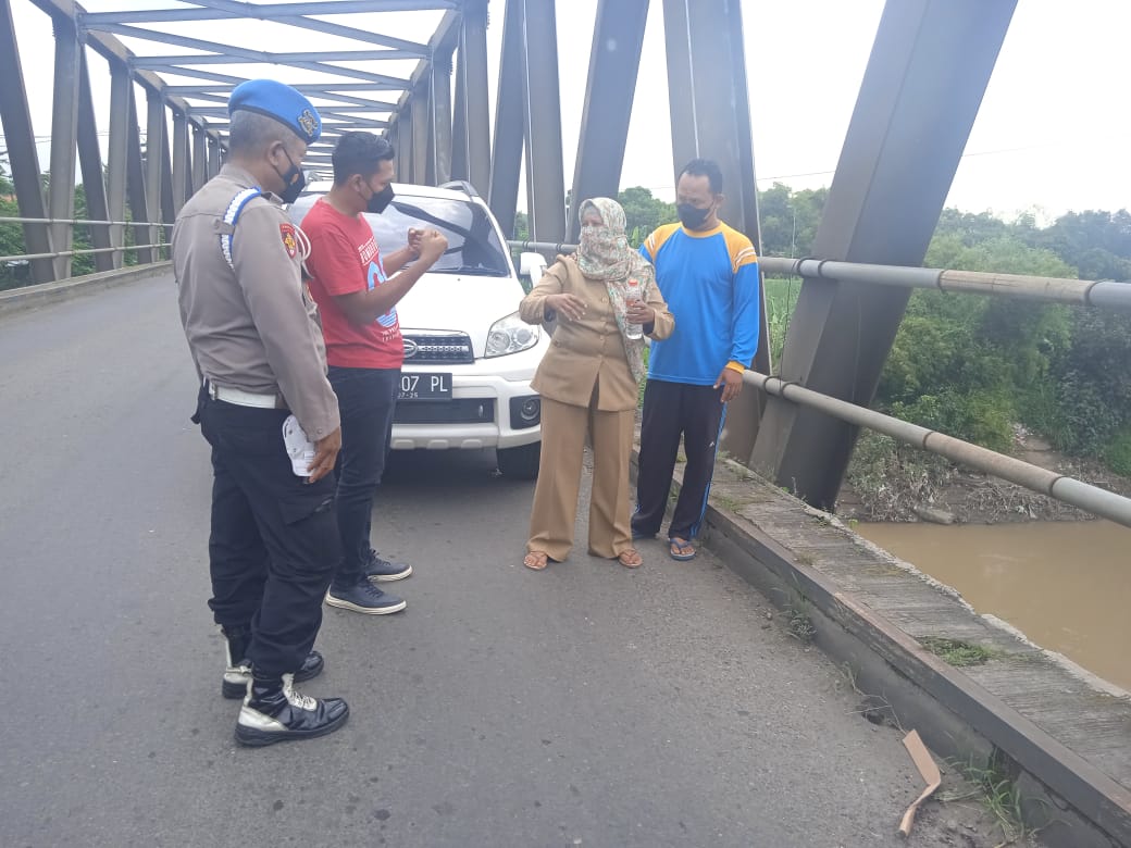 Sri Wahyuliati Ningsih (seragam coklat) memberi keterangan kepada pihak kepolisian di TKP jembatan Desa Tanjangrono, Kecamatan Ngoro, Kabupaten Mojokerto, Senin (21/2/2022)./ Foto: Susan